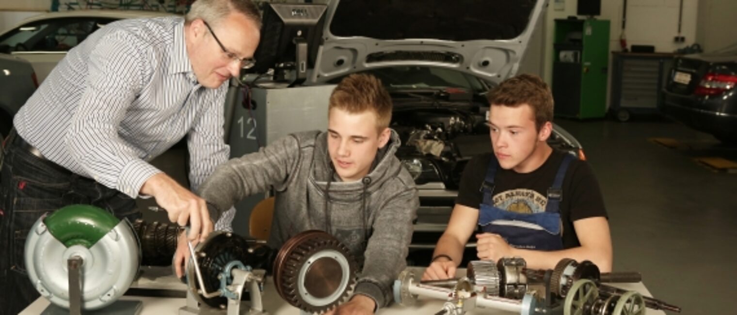 Lehrwerkstatt, ÜLU, Kfz, Unterricht, Ausbildung, Lehrlinge, Männer, Ausbildungsmeister, Gruppenfoto, Auto, Hebebühne, Messgeräte, Werkbank 