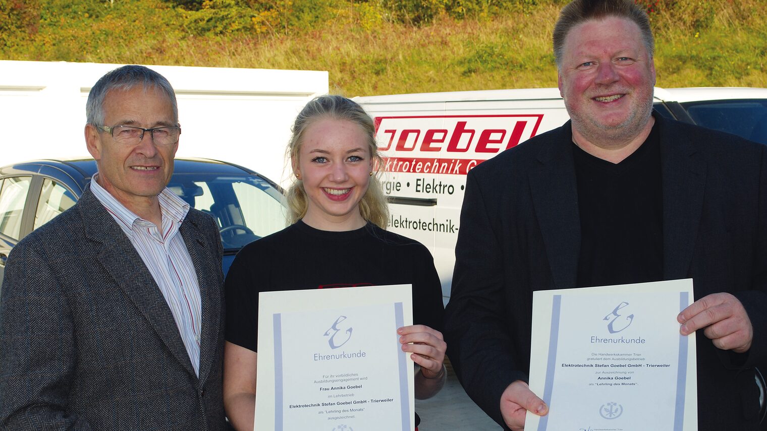 Kammerpräsident Rudi Müller (l.) bei der Urkundenübergabe an Annika und Stefan Goebel (r.) im Betrieb 