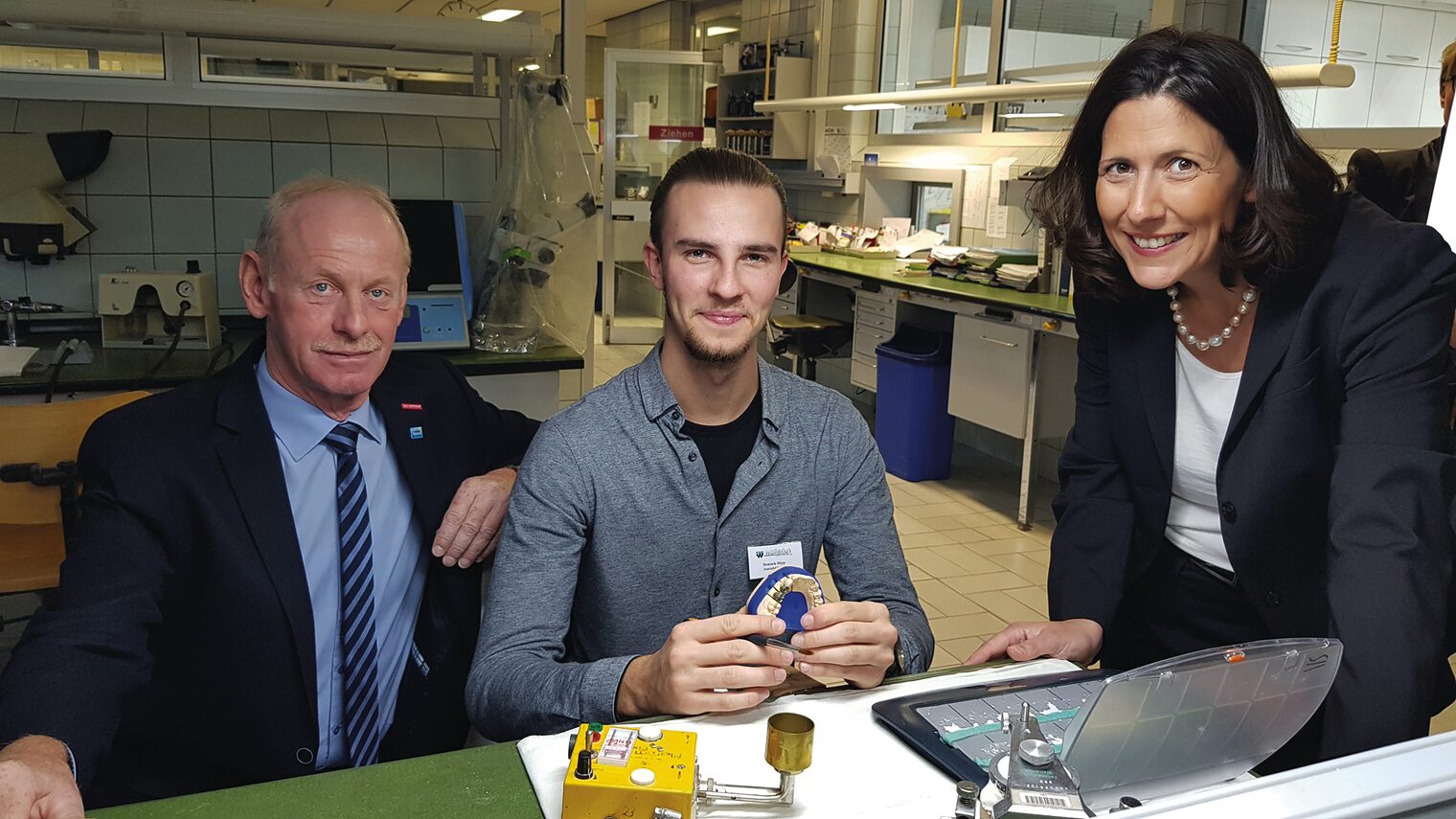 Ehrung zum Lehrling des Monats: Dominik Döpp im Ausbildungsbetrieb Zahntechnik Wallerius (Trier) v.l.: HWK-Vizepräsident Edgar Gröber, Dominik Döpp, Staatssekretärin Daniela Schmitt