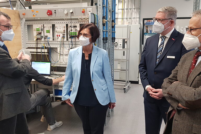 GF Thomas Sandner, Staatssekretärin Petra Dick-Walther, HGF Axel Bettendorf und Präsident Rudi Müller in der Elektrowerkstatt.